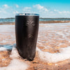SIC Matte Black Stainless Steel Tumbler in surf at the beach